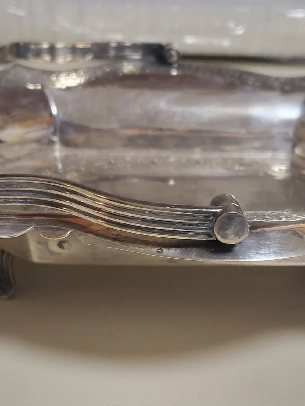 Silver-plated decorative tray with ornate scalloped rim and handles,